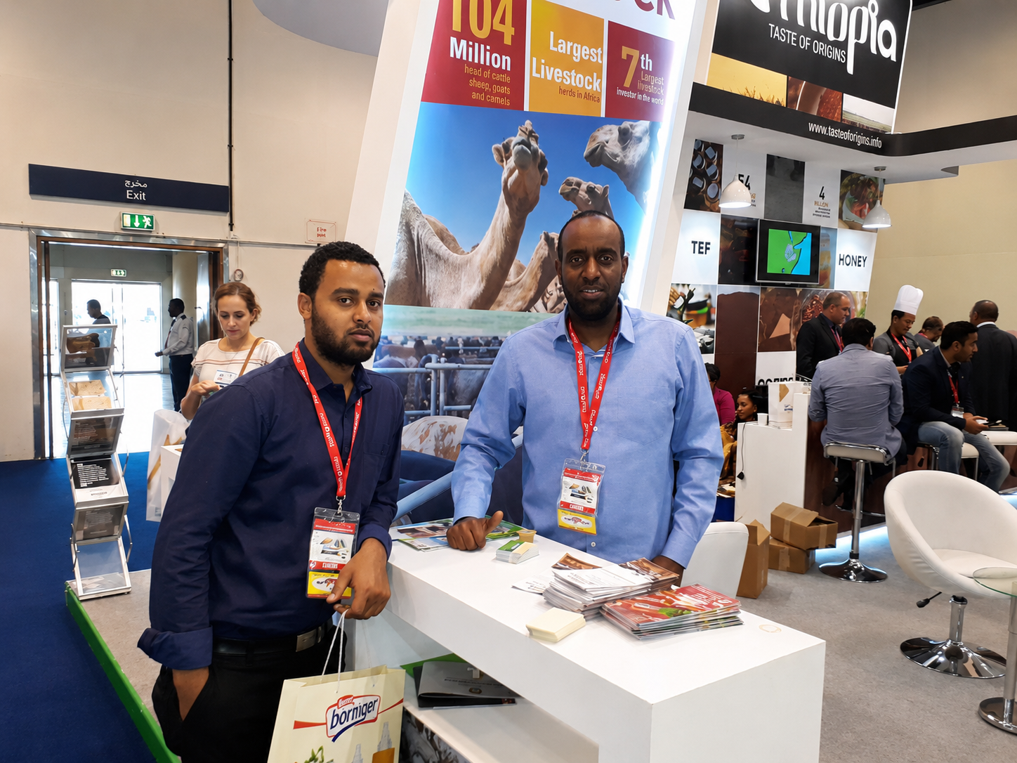 Abdulmuen Mohamed standing at the Ethiopia Taste of Origins trade pavilion counter during an international exhibition.